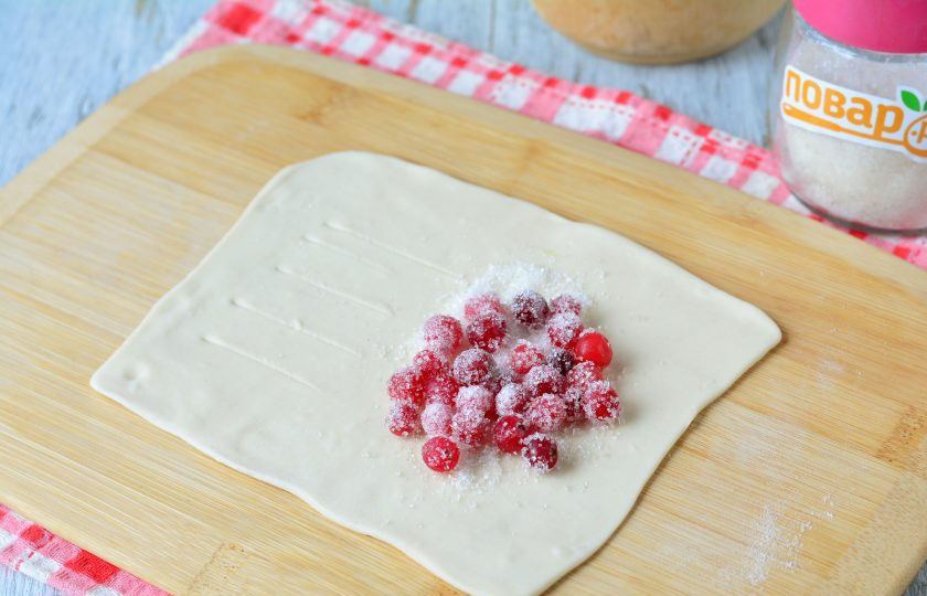 1. Этап. Слойки из слоеного теста с клюквой: На ту часть, где нет надсечек, выложите начинку из клюквы.