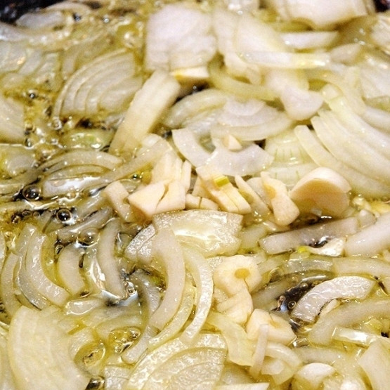 1. Этап. Курица с шафраном: Лук нарезаем тонкой соломкой, чеснок - очень мелко. В сотейнике разогреваем оливковое масло, кладем туда лук и чеснок, тушим на среднем огне до мягкости.