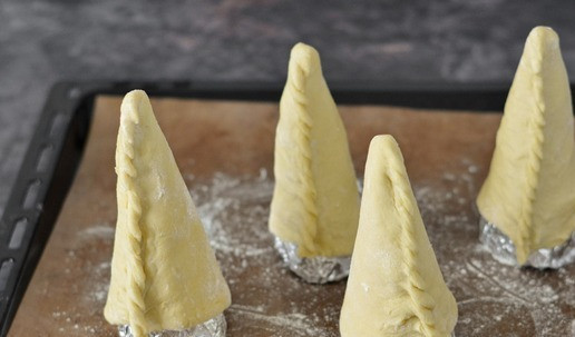 1. Этап. Коно пицца: Изготовьте столько конусов, сколько необходимо. Установите их вверх ногами на противень и отправьте в нагретую духовку. С выпечкой конусов нюанс такой - важно их не пересушить, но пропечь внутри. Помните, что они ещё будут готовиться с начинкой. Поэтому лучше выпекайте с пАром. Делается это так: на дно духовки установите поддон и нагрейте духовку до 180°С. В нагретую духовку поместите противень с конусами, а на поддон плесните пол-стакана воды. Получившийся пар не даст конусам высохнуть. Выпекайте конусы из теста 5-10 минут до лёгкого розового цвета.