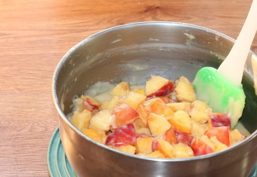 1. Этап. Пирог солнечный: 10. Перекладываем дольки персика в миску с тестом и перемешиваем.