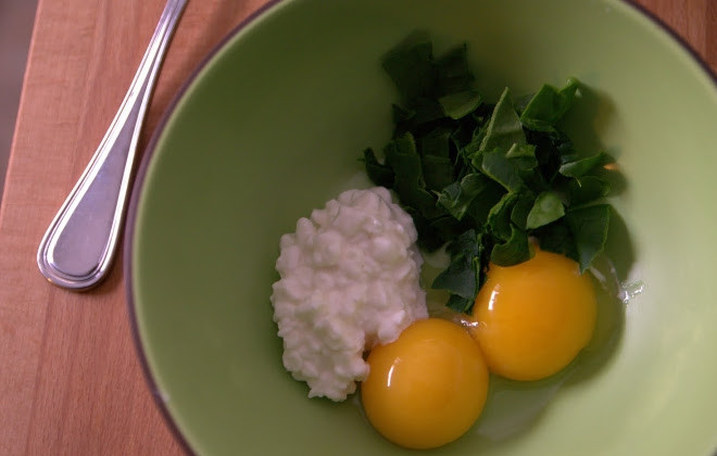 1. Этап. Яичница с творогом: 1. Отделите белок от желтка. В миску выложите куриный желток, одно яйцо, нарезанные листья шпината и творог.