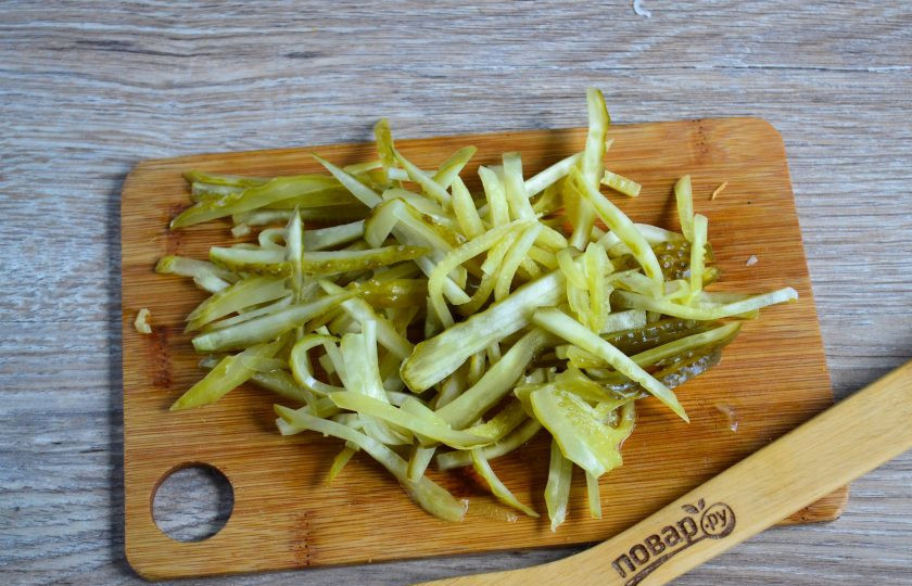 1. Этап. Салат из сердца с морковью и луком: Огурчики нарежьте соломкой.