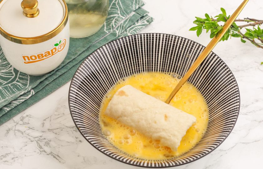 1. Этап. Лаваш с творогом в аэрогриле: Взбейте куриные яйца в пиале или салатнике и окуните в яичную массу каждую заготовку со всех сторон.