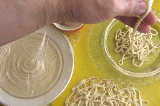 1. Этап. Дунганская лапша: 7. Продолжайте вытягивать лапшу, пока она не станет достаточно тонкой. В процессе обязательно смазывайте руки маслом, чтобы было удобно работать с тестом.