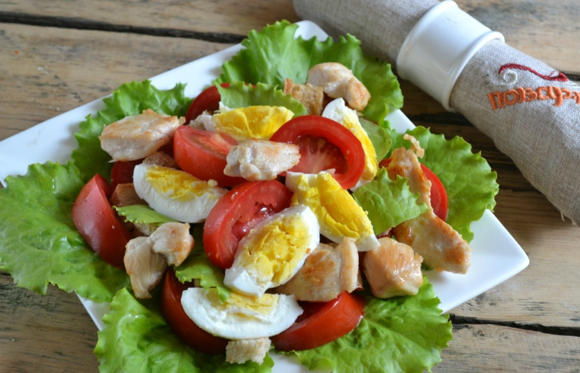 1. Этап. Салат Цезарь с курицей и сухариками: 5. Соберите салат. На дно тарелки положите промытые листья салата, сверху положите помидоры, сухарики, порезанные дольками яйца и кусочки курицы.
