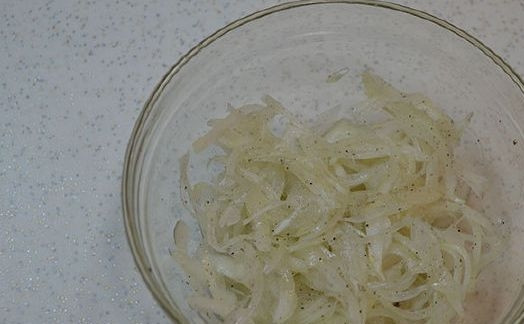 1. Этап. Нарезка из селедки на праздничный стол: Лук почистите и нарежьте полукольцами. К луку добавьте маринад из сока лимона, перца, соли и сахара. Отожмите перья руками.