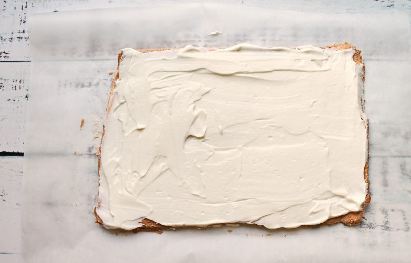 1. Этап. Меренговый рулет с творожным кремом: В чашу выложите творожный сыр, сахарную пудру, влейте сливки и взбейте до пышной массы. Нанесите творожный крем на остывший корж ровным слоем.