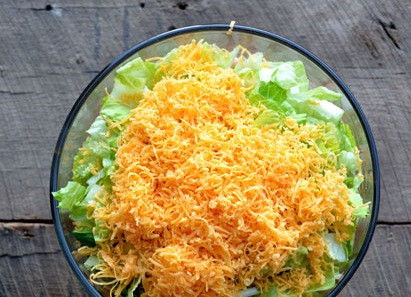 1. Этап. Слоеный салат Праздничный: 6. Сыр натрите на терке и распределите сверху шестым слоем.