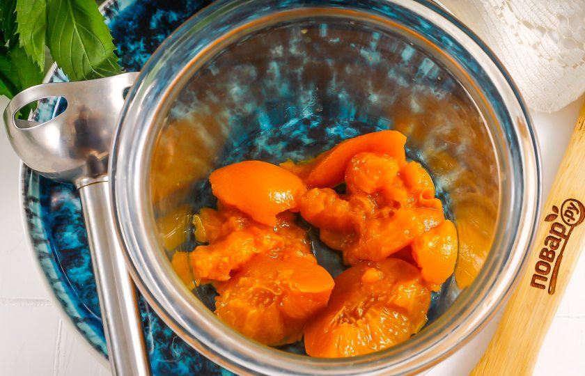 1. Этап. Коктейль Беллини: Нарежьте консервированные персики на части и выложите нарезку в чашу блендера или измельчителя. Если с персиков можно счистить кожуру, то сделайте это, чтобы она не попадалась при дегустации напитка.