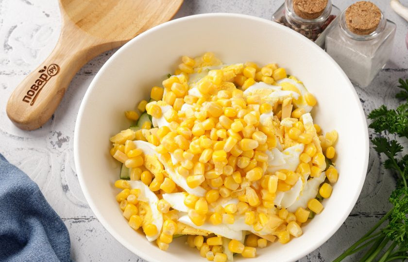 1. Этап. Салат с кукурузой, огурцом и сыром: Добавьте кукурузу, слив с неё предварительно жидкость.