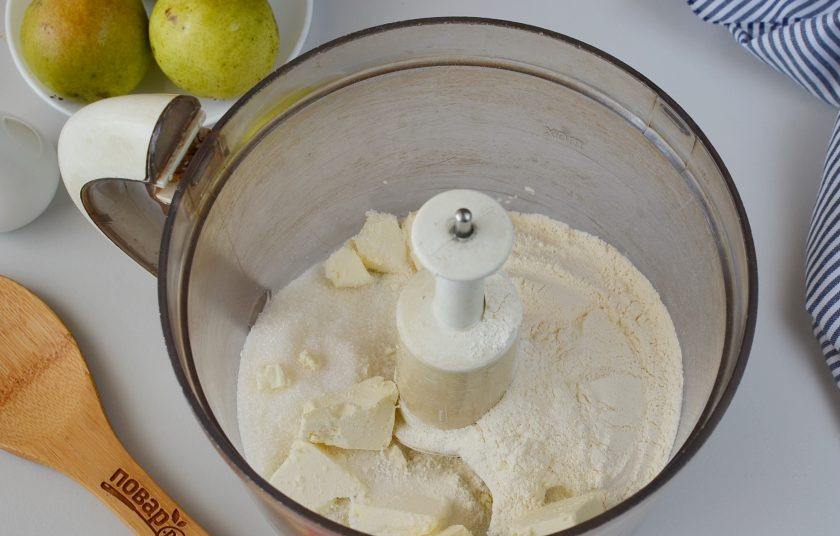 1. Этап. Грушевый пирог: В чашу кухонного комбайна выложите муку, соль, сахар, разрыхлитель, сливочное масло. Включите комбайн на пару минут.