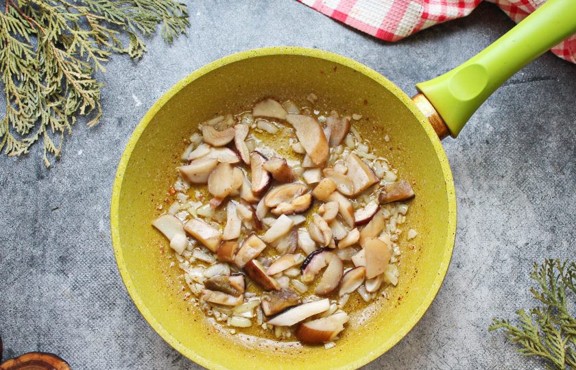 1. Этап. Паста с фаршем и белыми грибами: Белые грибы порежьте на дольки и выложите в сковороду. Обжаривайте грибы на среднем огне в течение 10-12 минут, перемешивая.