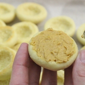 1. Этап. Пирожные Персики: 10. Итак, начинка готова. Теперь возьмите половинку, начините углубление кремом, слегка размажьте по плоской поверхности пирожного и склейте со второй половинкой. В центральное углубление начинку выкладывайте с горочкой, т. к. сладкая 