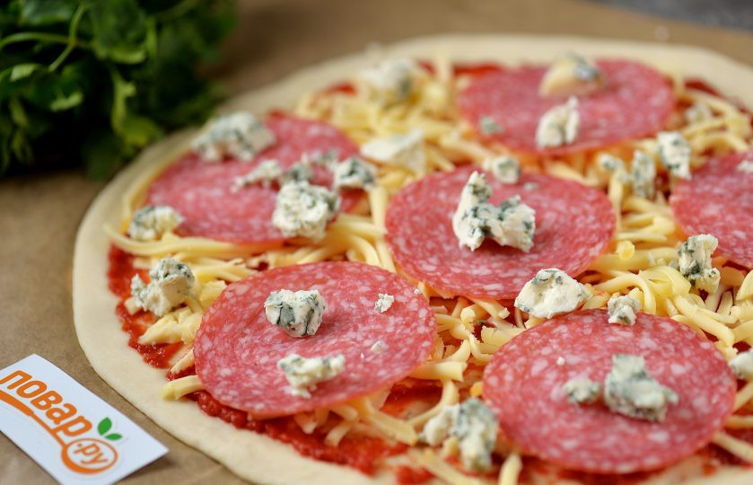 1. Этап. Пицца с горгонзолой: Разложите ломтики колбасы, посыпьте все поломанным на мелкие кусочки сыром горгонзолой. Отправьте противень в предварительно разогретую до 250 градусов духовку на 8 минут. Противень установите ровно посередине духовке, конвекцию не включайте.