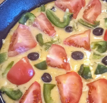 1. Этап. Нисуазские пироги для пикника: Вылить тесто в ёмкость для запекания. Разровнять. Сверху выложить единым слоем кусочки помидоров, лук, жареный перец и маслины. С помощью кисточки смазать пирог оливковым маслом