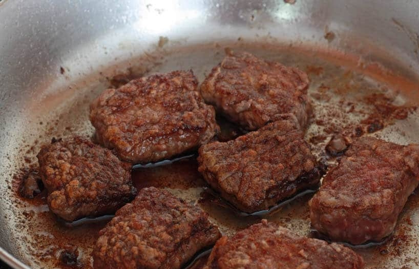 1. Этап. Вкусная говяжья подлива: 4. В сковороде разогрейте растительное масло, выложите мясо и обжаривайте его с двух сторон до румяной корочки. Выложите мясо со сковороды в тарелку.