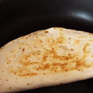 1. Этап. Кесадилья с индейкой: Без масла нагреваем сковороду с толстым дном. Формируем кесадильи - разворачиваем тортилью, на одну половину кладем начинку, другой ее накрываем. Разогреваем каждую кесадилью на сковороде полторы минуты с каждой стороны - за это время сыр расплавится, а остальные ингредиенты станут теплыми.