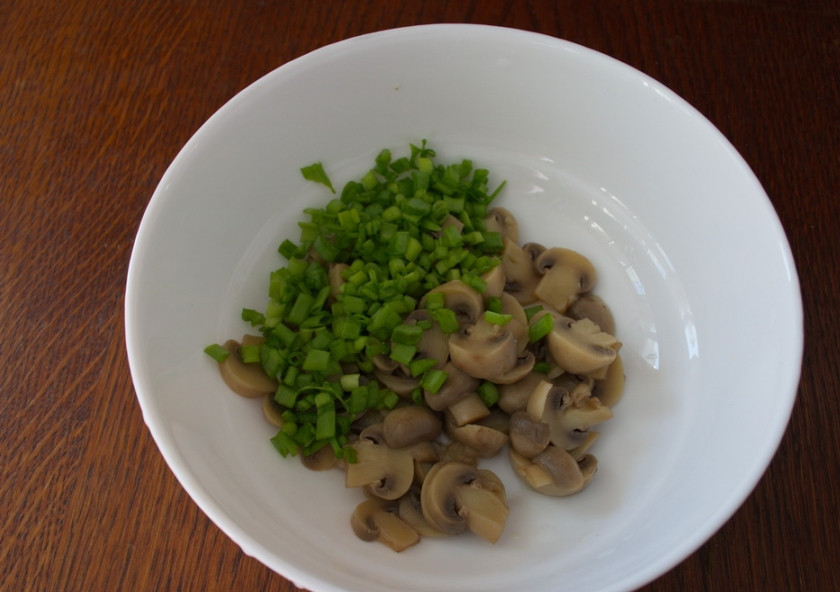 1. Этап. Салат с шампиньонами и сыром: Сложите в салатник. Добавьте измельченный зеленый лук. Кроме лука можно использовать и другую имеющуюся зелень.