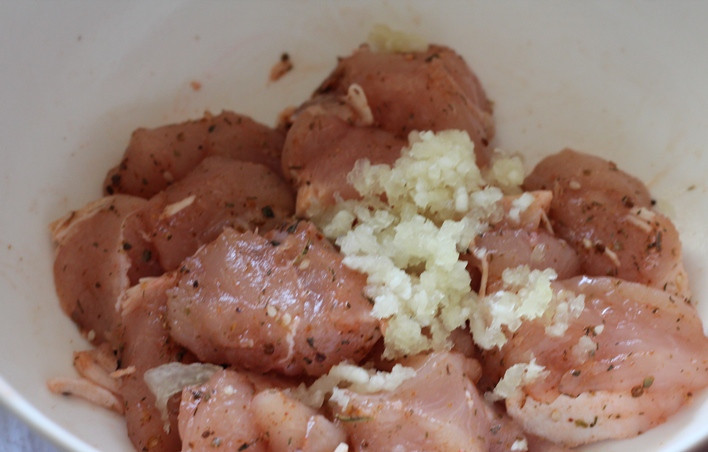 1. Этап. Курица кусочками в мультиварке: Добавляем к мясу выдавленный через пресс чеснок.