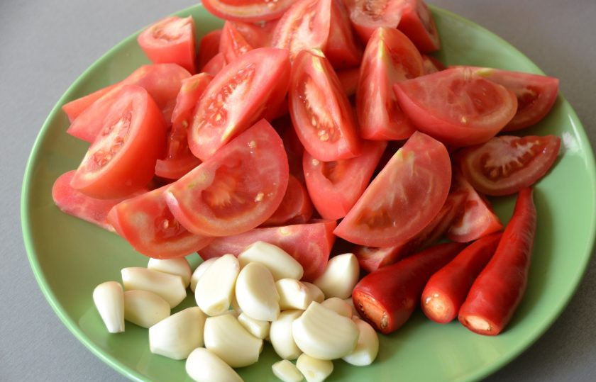 1. Этап. Закуска Кобра: Нарежьте дольками помидоры, очистите чеснок, подготовьте перец чили. Если не хотите, чтобы закуска получилась очень острая, семена можно убрать.