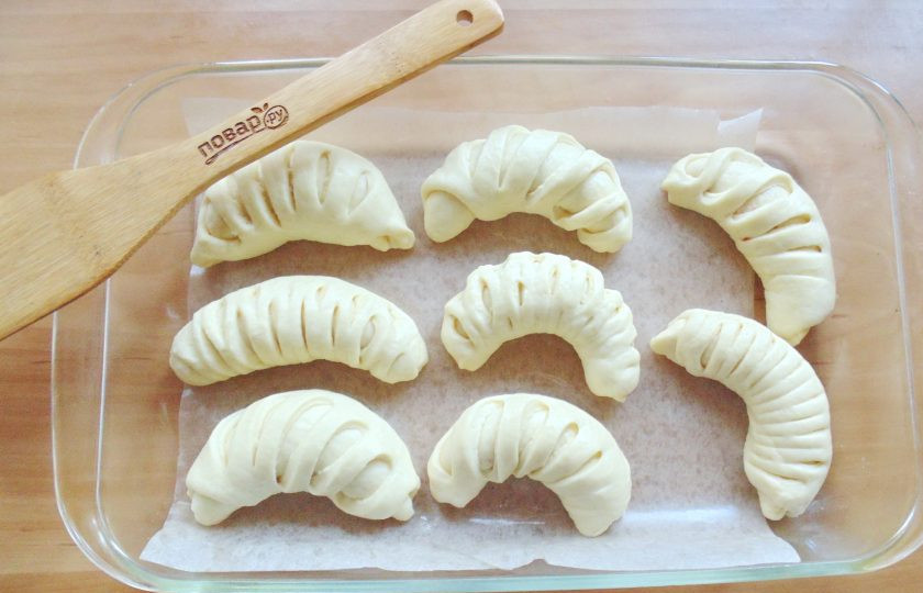 1. Этап. Дрожжевые рогалики с вишней: Форму для выпекания застелите пекарской бумагой. Выложите рогалики, дайте им немного подойти в течение 25-30 минут.