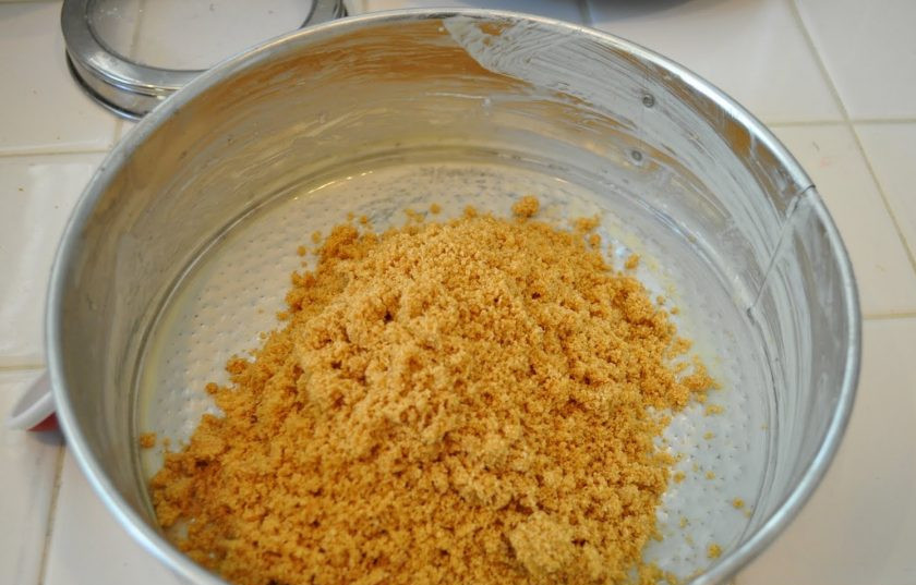 1. Этап. Настоящий чизкейк Нью-Йорк: Форму для выпечки смажьте маслом. Измельчите печенье в крошку. Добавьте масло с сахаром. Разотрите массу. Выложите её на дно формы.