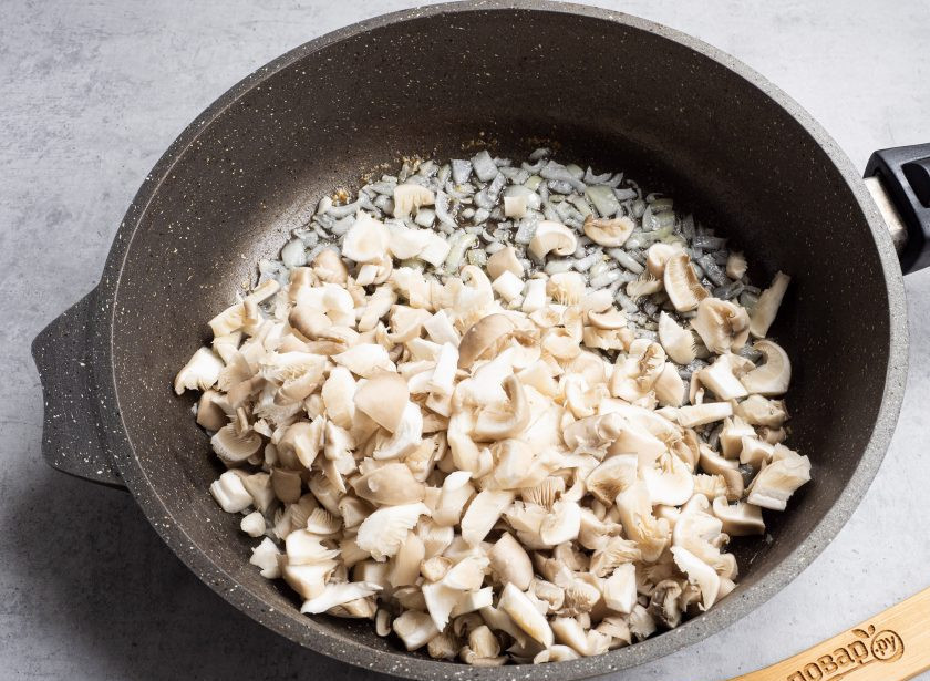 1. Этап. Гречка в сливочном соусе: Лук нарежьте и обжарьте в растительном масле до прозрачности. Грибы помойте, обсушите бумажным полотенцем, нарежьте и добавьте на сковороду.