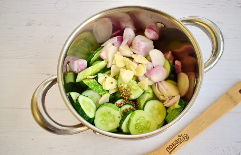 1. Этап. Салат зимний из огурцов: 2. Огурцы и лук нарежьте кольцами, заложите в кастрюлю. Добавьте остальные ингредиенты.