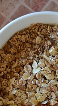 1. Этап. Смузи-боул с персиками: Миндаль измельчить в крошку. В широкую пиалу вылить кефирную смесь. Сверху выложить дольки персика, часть хлопьев и крошку миндаля.