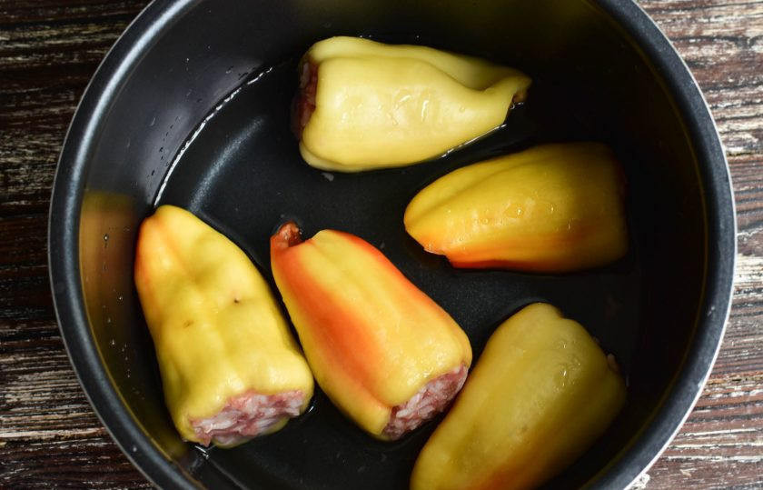 1. Этап. Фаршированные перцы в скороварке: Выложите овощи в чашу скороварки. Залейте их водой. Она должна почти полностью покрывать овощи.