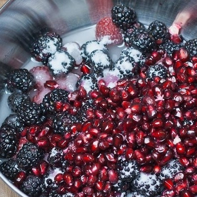 1. Этап. Чизкейк с ежевикой, малиной и гранатом: Кладем в кастрюлю ягоды, гранат, оставшийся сахар и воду.
