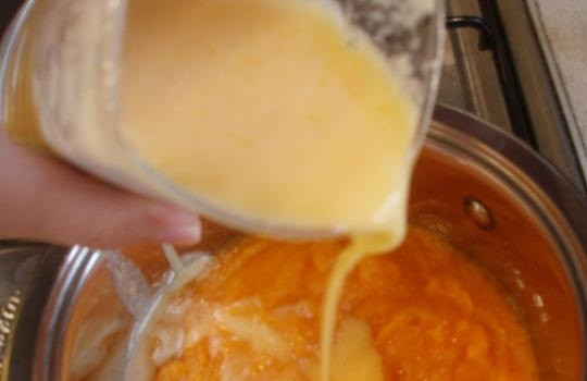 1. Этап. Кисель из тыквы: 4. Апельсиновый сок можно сделать самостоятельно, а можно купить уже готовый. Вливаем сто пятьдесят грамм сока к тыквенному пюре, перемешиваем все и перекладываем в сотейник. Столовую ложку крахмала разводим в оставшихся пятидесяти граммах сока и отправляем в пюре. Доводим тыквенный кисель до кипения. Как только появились первые пузырьки, сразу снимаем с огня, добавляем сахар и перемешиваем до полного растворения.