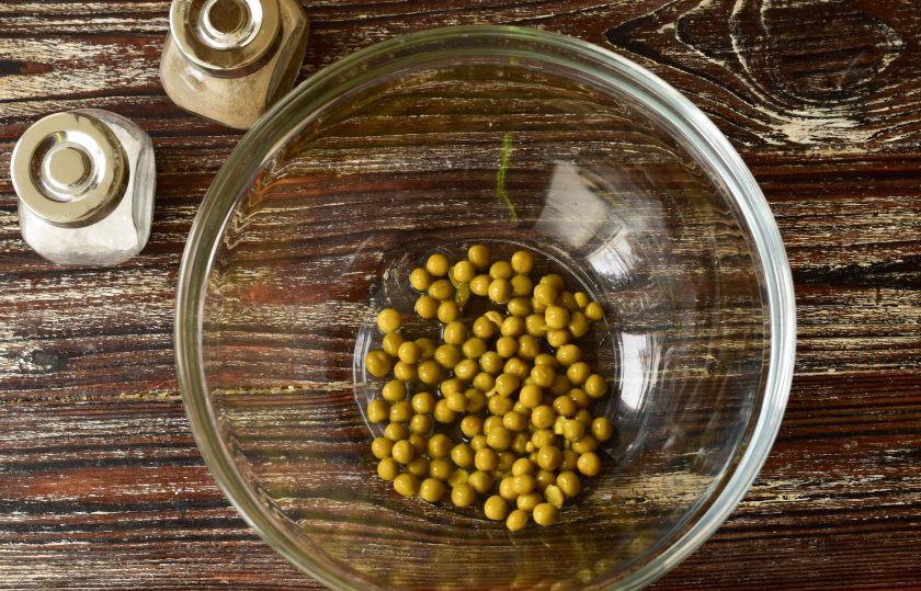 1. Этап. Оливье с печенью трески: В миску выложите консервированный горошек.