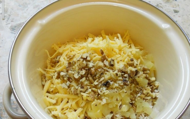 1. Этап. Салат с курицей и ананасами в тарталетках: 2. Твердый сыр натираю на крупной терке и кладу в кастрюлю, орехи измельчаю ножом и добавляю в кастрюлю, немного оставляю для украшения.