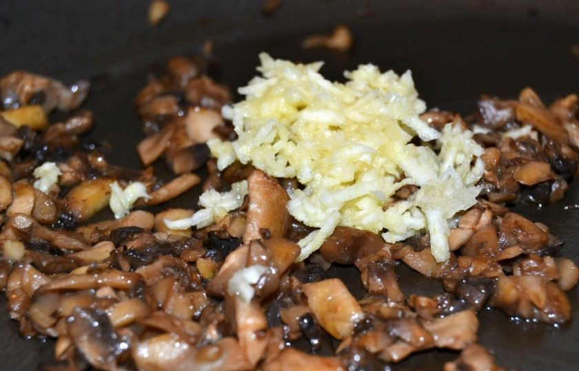 1. Этап. Фаршированный авокадо в духовке: 8. Добавьте к уже обжаренным грибам измельченный чеснок, готовьте еще 10-20 секунд.