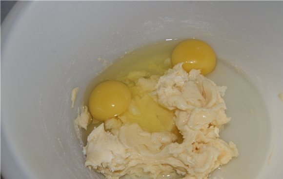 1. Этап. Бисквит в микроволновке: Хорошенько перемешать ложкой масло с пудрой и добавить яйца.