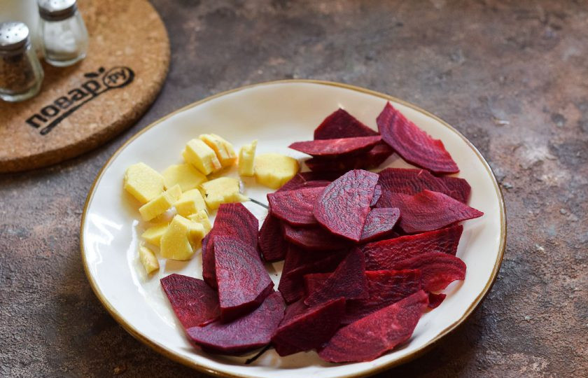 1. Этап. Свекла маринованная с имбирем на зиму: Свеклу очистите, ополосните, просушите. Нарежьте свеклу тонкими пластинами. Имбирь очистите и нарежьте небольшими кусочками. Очистите и нарежьте дольками чеснок.