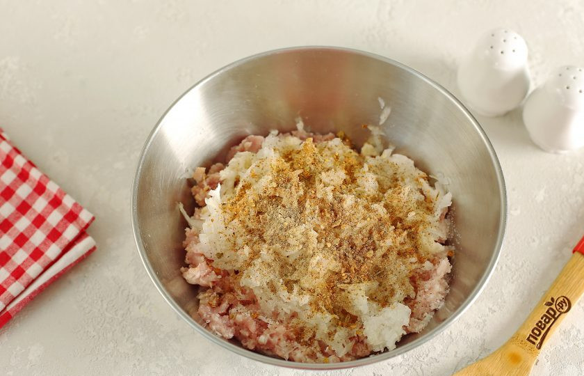 1. Этап. Фрикадельки в соусе Бешамель: Переложите фарш в глубокую миску. Добавьте тертый на крупной терке лук, отжатый батон, соль и специи по вкусу.