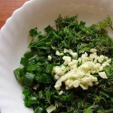 1. Этап. Жареные баклажаны с чесноком: Зелень мелко нарубить, добавить к ней раздавленный чеснок.