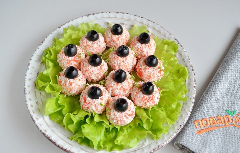 1. Этап. Салат-закуска Ёлочные шарики: Выкладывайте шарики на листья салата. Оливки порежьте на половинки и каждую половинку положите на шарик, вдавите немного. Вот и готовы 