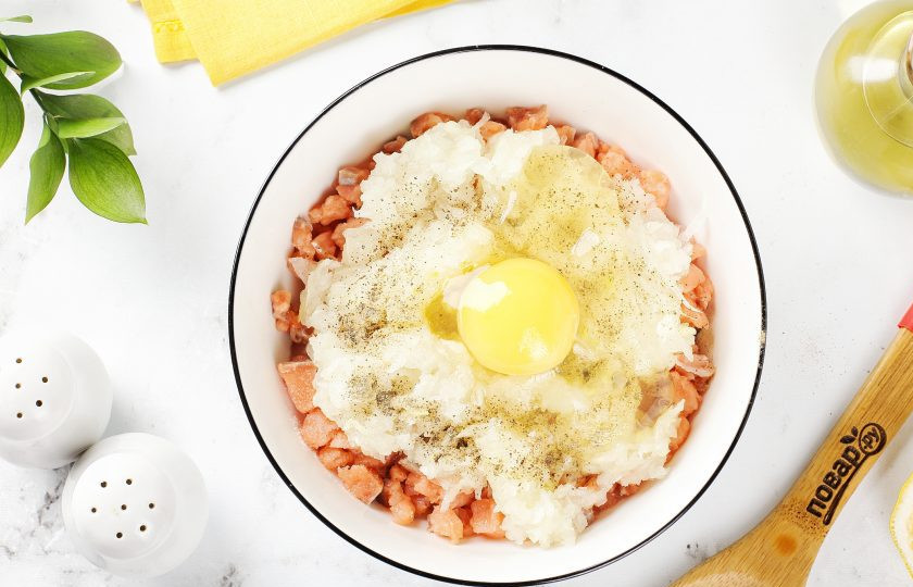 1. Этап. Котлеты из горбуши с лимоном и рисом: Добавьте тёртый на крупной тёрке лук, яйцо, соль и молотый перец по вкусу.