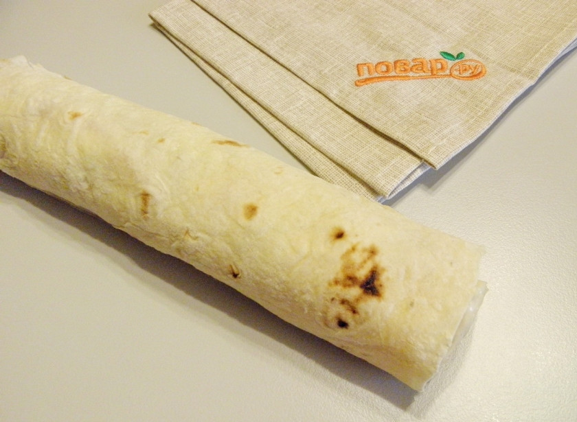 1. Этап. Рулет из лаваша на Новый Год: Аккуратно и плотно сверните лаваши с начинкой в рулет. Заверните в пищевую пленку и отправьте в холодильник на 2-2,5 часа. За это время лаваш станет мягче, пропитается и примет форму.