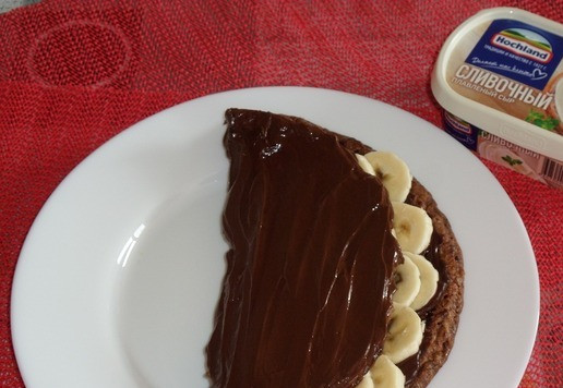 1. Этап. Шоколадный овсяноблин с бананом: Накрываем начинку краем блина. Поверх выкладываем оставшуюся часть шоколадно-сырной массы и равномерно распределяем.