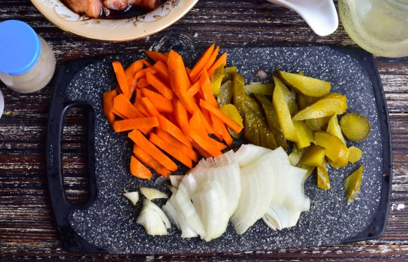 1. Этап. Свинина в карамели по-китайски: Нарежьте соломкой соленый огурец и морковь, лук — полукольцами.