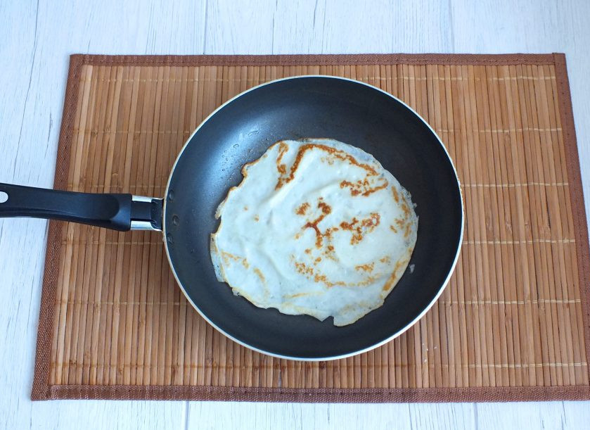 1. Этап. Лапшевник из блинов: Разогрейте сковороду. Смажьте единожды растительным маслом. Налейте тесто. Оно получается очень жидким и хорошо растекается по сковороде. Обжарьте тонкие блинчики с двух сторон до румяного состояния. Стоит учесть, что перед каждым набором теста в половник, его необходимо размешать в чаше, т.к. крахмал имеет свойство оседать вниз теста.