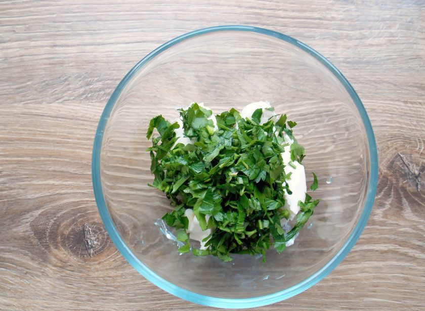 1. Этап. Тортильи с красной рыбой: Переложите в миску творожный сыр. Петрушку вымойте, обсушите и мелко порежьте. Добавьте петрушку в миску с сыром и перемешивайте, пока петрушка равномерно не распределится.