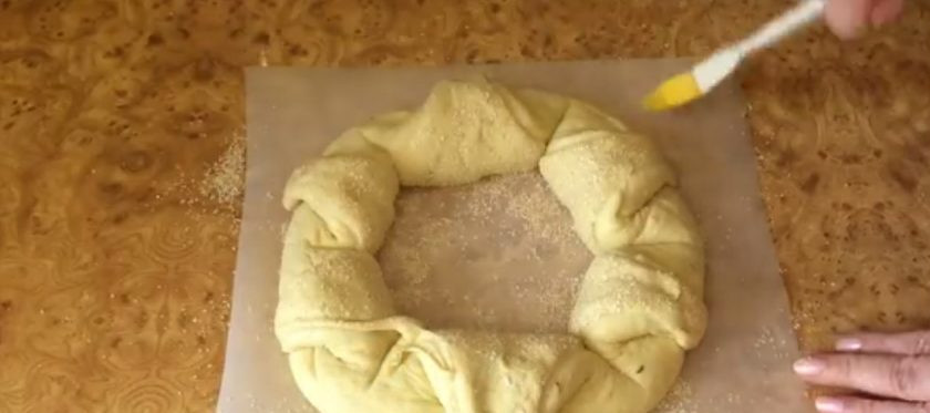 1. Этап. Пшеничный калач Солнышко: 6. Сделайте три диагональных надреза, не доходя до краев теста. Полученные внутренние углы треугольников выверните наизнанку и выложите поверх теста. Стряхните с пергамента лишние отруби, накройте пленкой и оставьте на 1,5 часа.