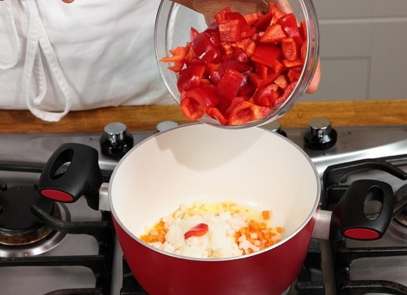 1. Этап. Телятина тушеная с овощами: В кастрюле разогреваем масло, обжариваем мелко нарезанные лук и морковь. Добавляем крупно нарезанный болгарский перец, обжариваем 2 минуты.