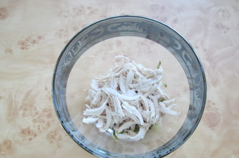 1. Этап. Салат с курицей и лапшой из омлета: Куриное филе порвите на волокна и добавьте к огурцам.