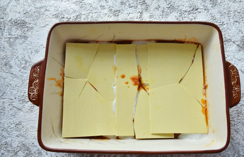 1. Этап. Лазанья с фаршем от Джейми Оливера: На белый соус выложите листы лазаньи. Джейми советует разбить пасту черенком ложки. В готовом виде ее легче будет нарезать на порции.